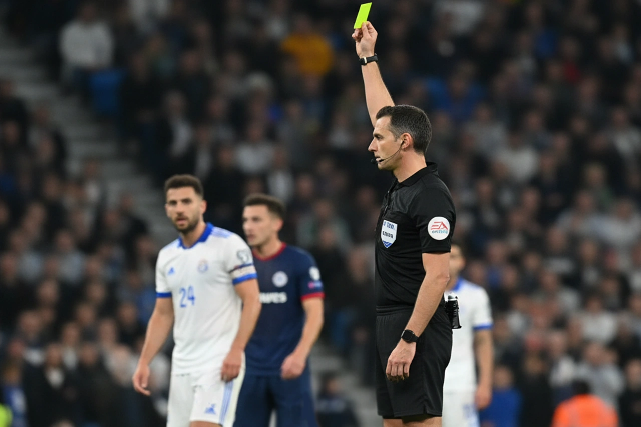 Scheidsrechter toont een gele kaart tijdens een internationale voetbalwedstrijd